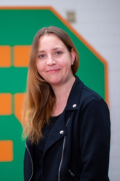 Doreen Lüttmann vor dem Ebrecht Reker Logo